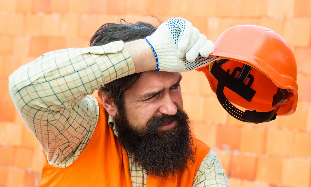 OSHA Issues First-Ever Hazard Alert for Heat - Construction Worker Wiping Sweat From His Forehead